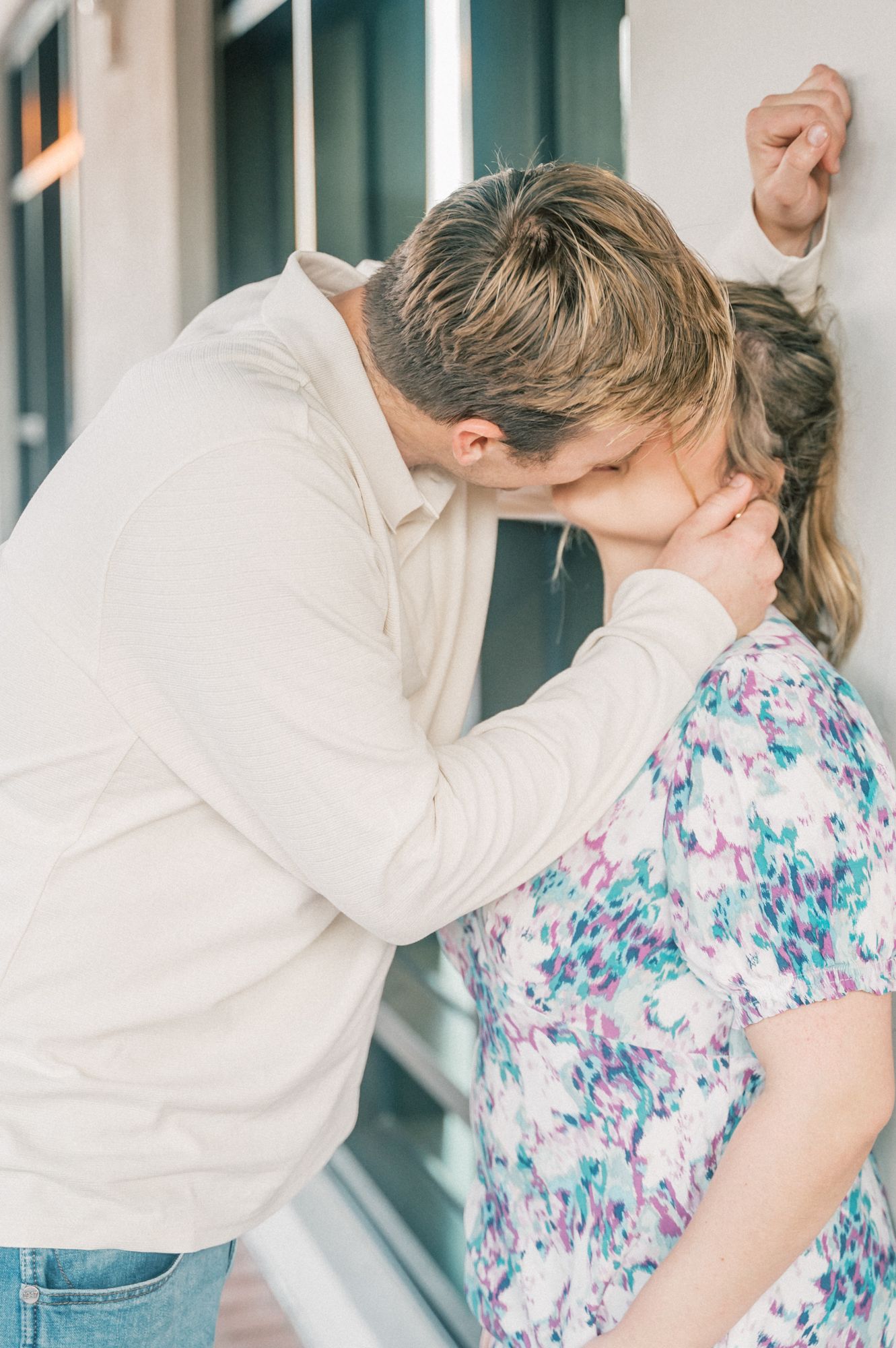 A playful dancing sequence between a couple against a white wall background.
