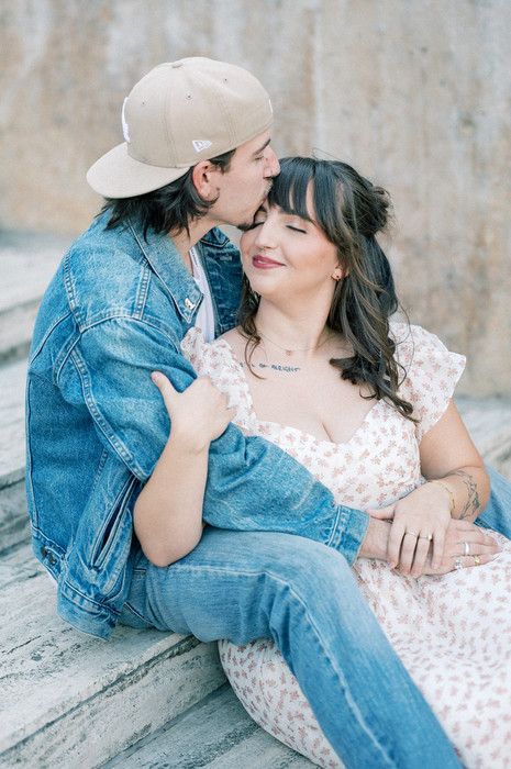 Casual couple's photoshoot with denim jacket and polka dot dress on concrete steps.