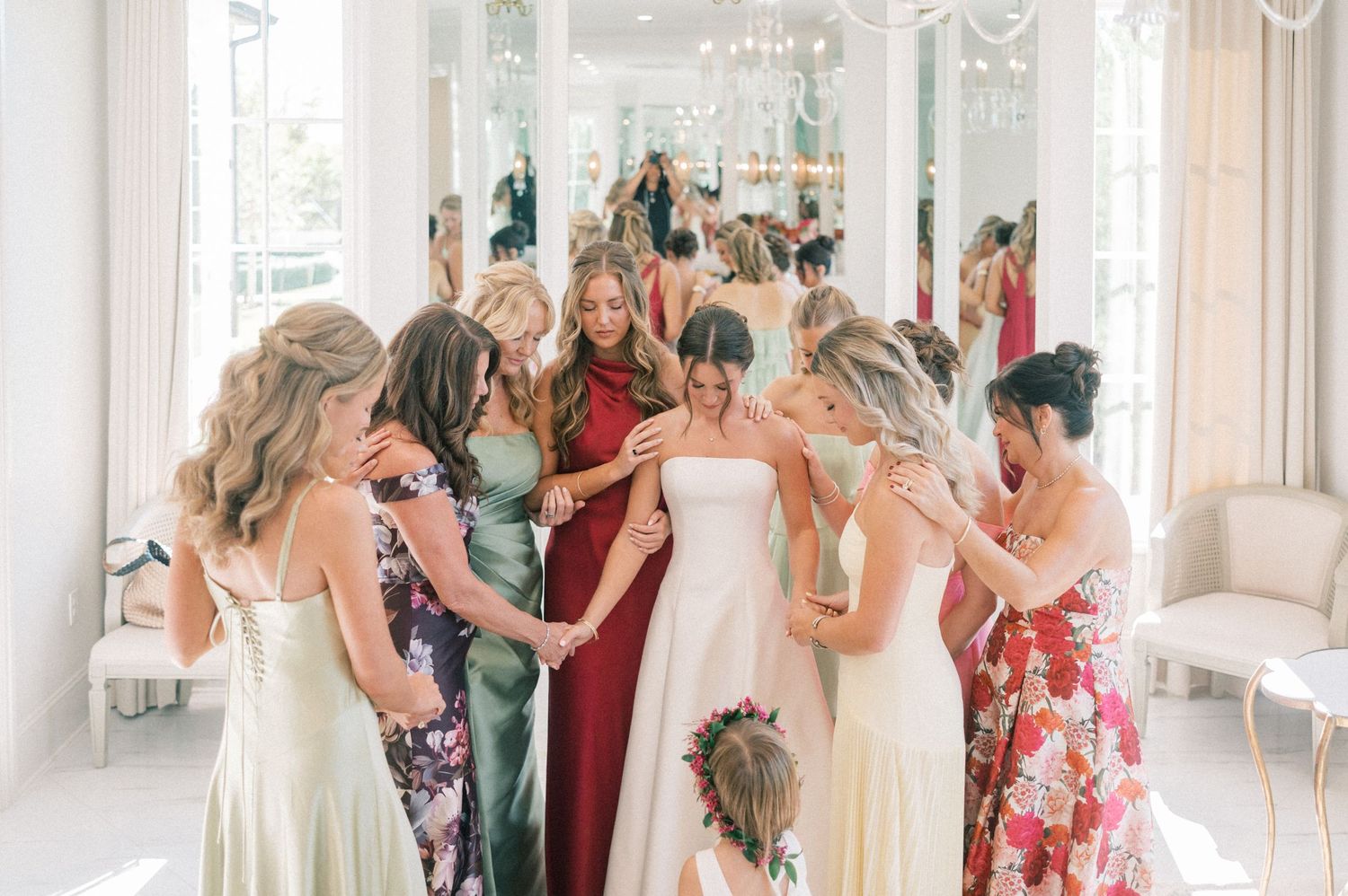 Elegant wedding venue filled with guests under sparkling chandeliers.