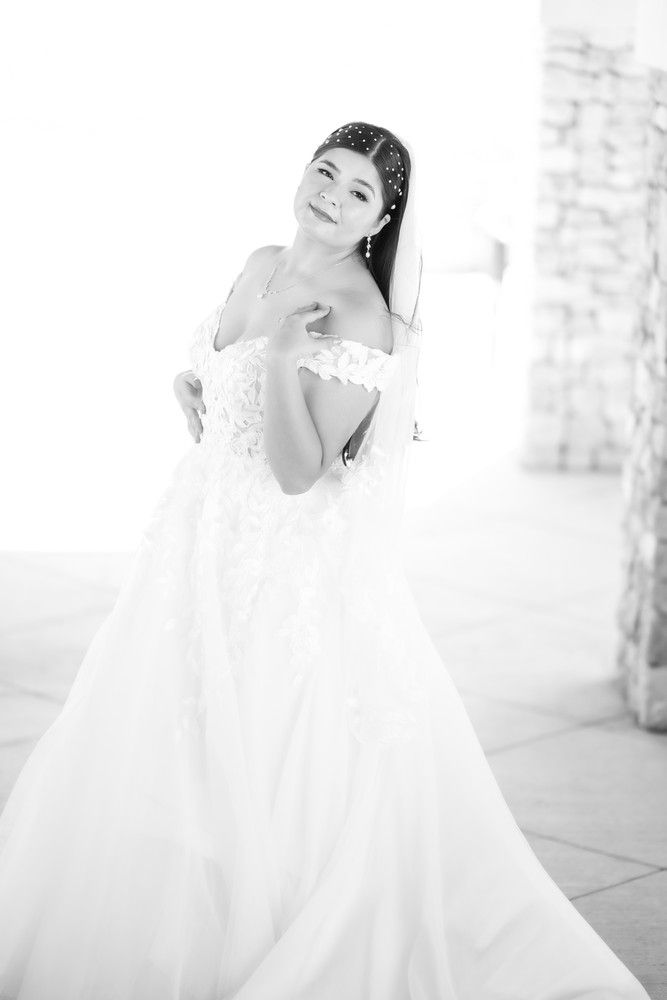 A black and white portrait of a bride in a strapless wedding gown.