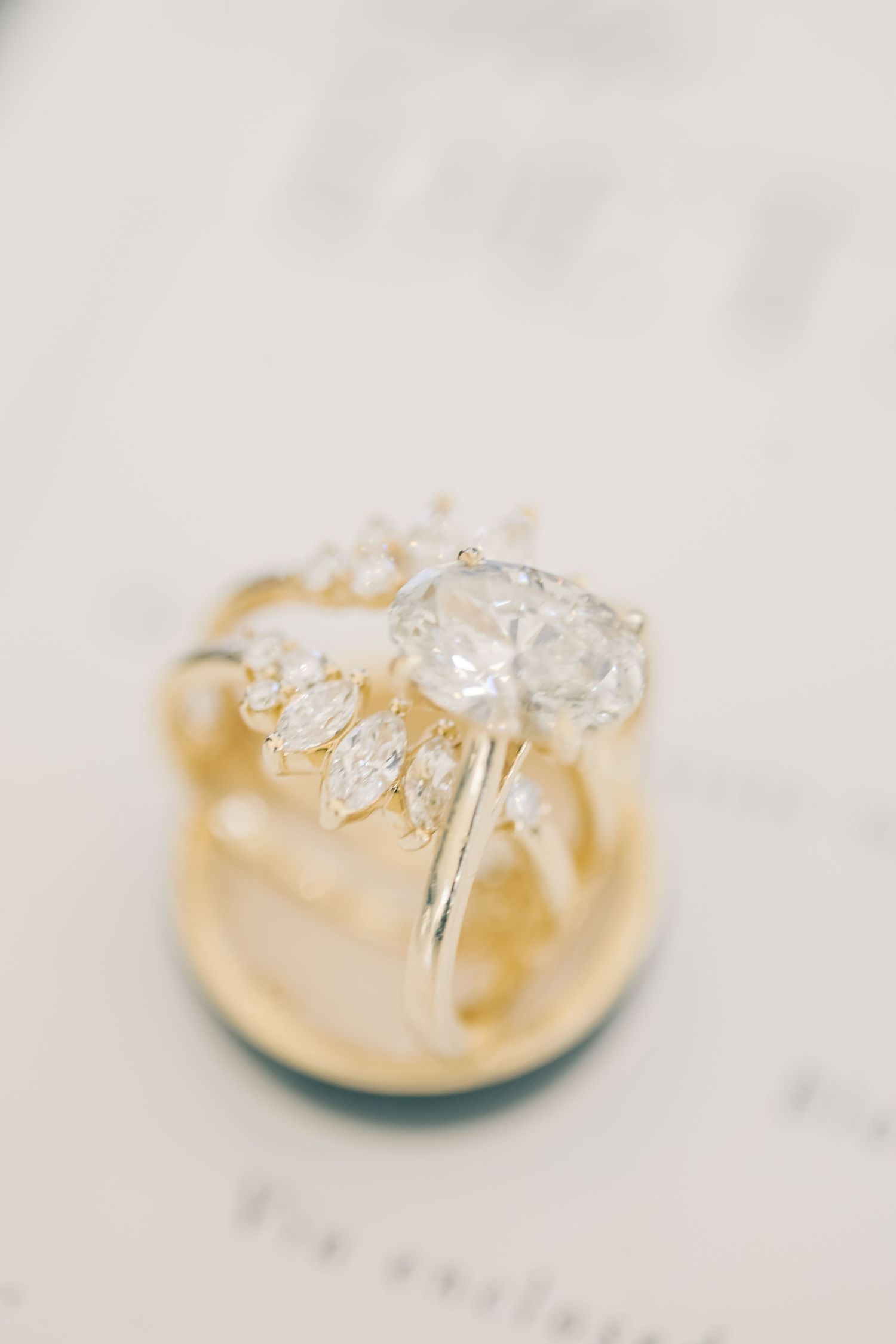Close-up of a pear-shaped diamond engagement ring with marquise diamond wedding band in gold.