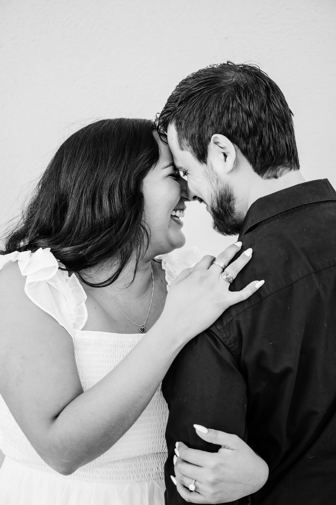 Black and white photo sequence captures tender moments between a couple in white and black attire.