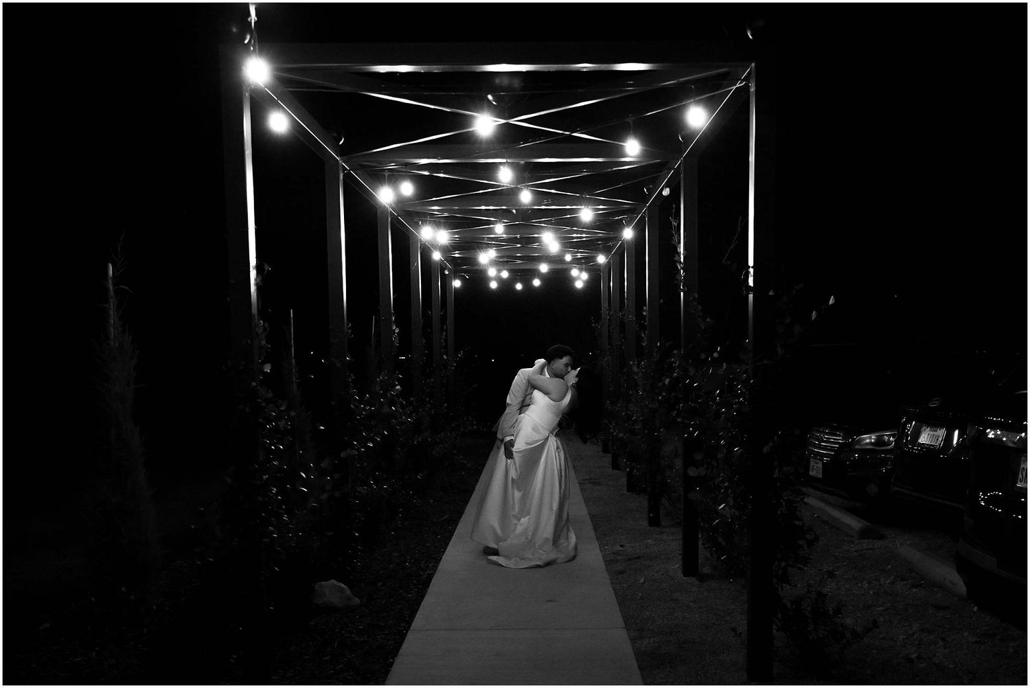 String lights illuminate a dark pathway at night creating a romantic ambiance.
