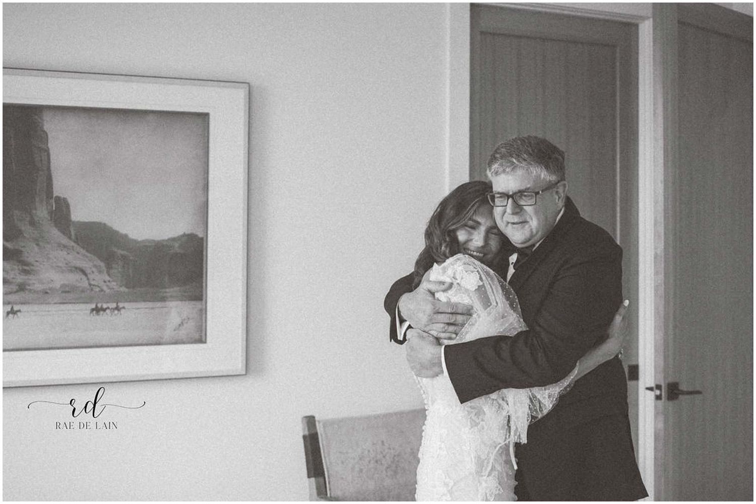 Black and white wedding photos showing emotional first look moments in an indoor setting.
