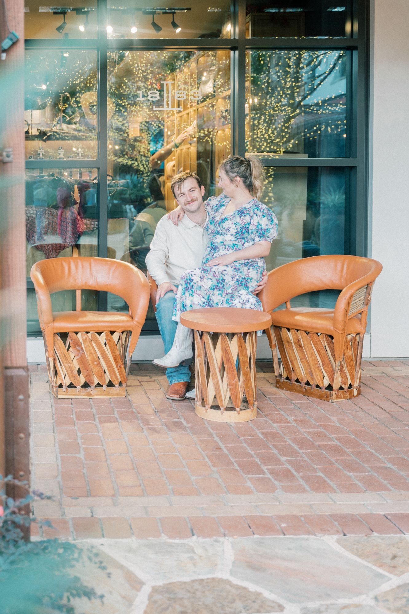 Couple relaxing on southwestern style patio furniture near storefront windows.