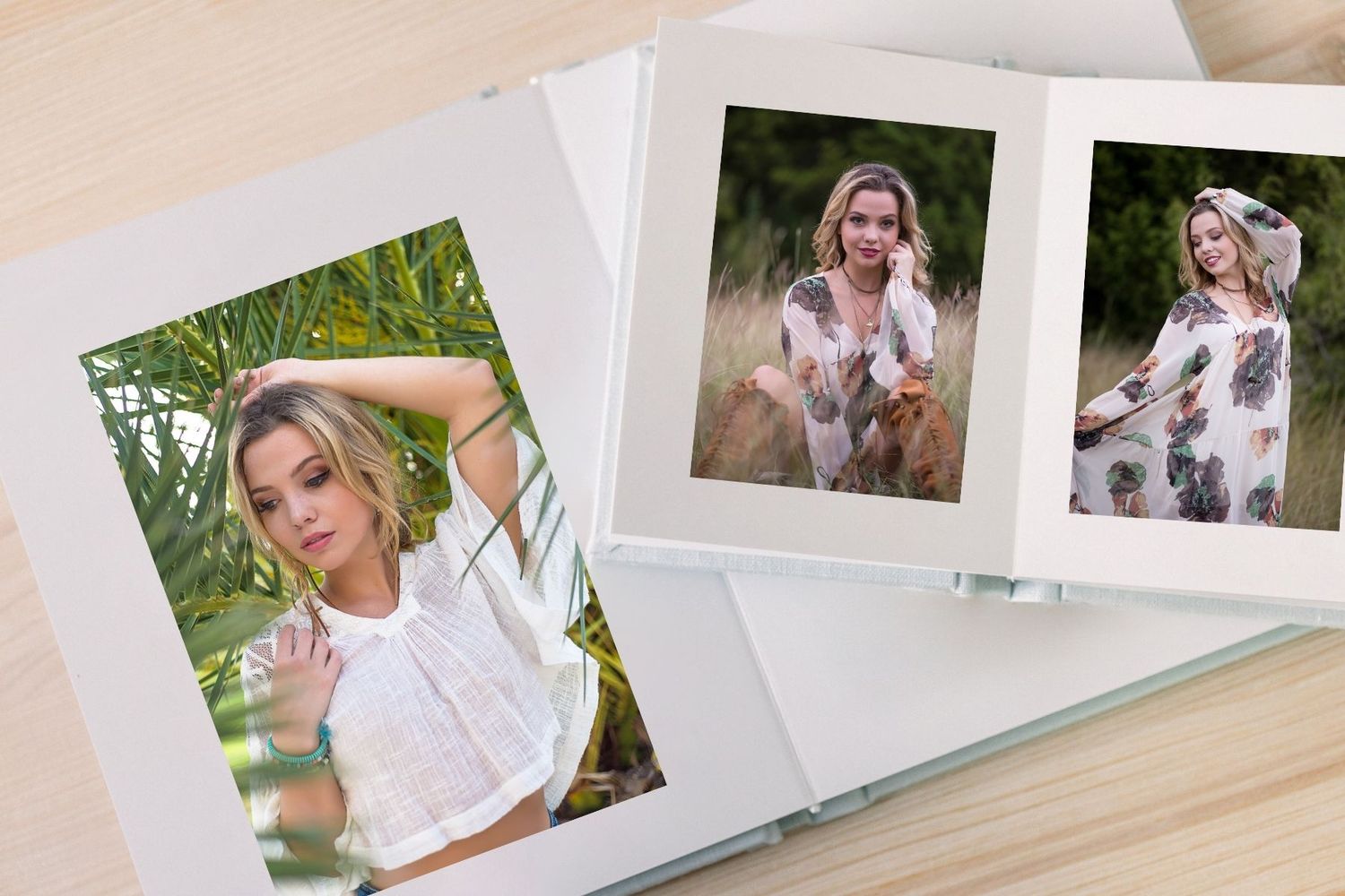 Open photo album displaying portraits of a blonde woman in white top and floral dress on a wooden surface.