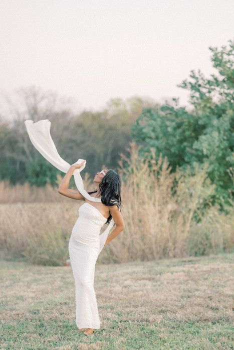 Artistic outdoor photography with billowing white fabric creating movement against natural scenery.
