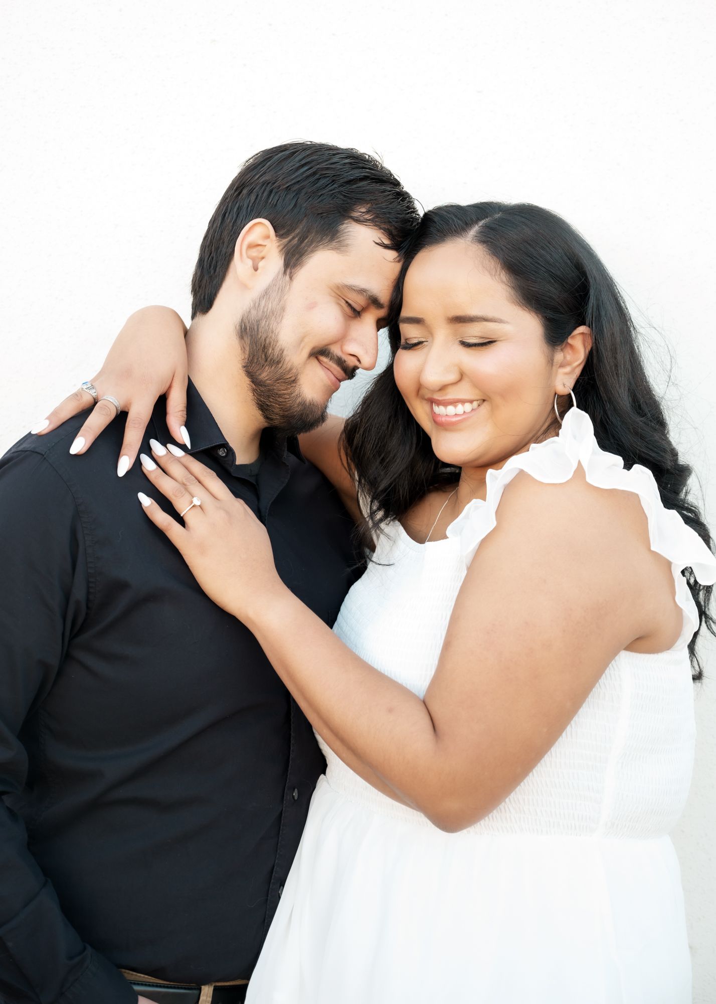 Series of romantic poses showing a couple embracing and laughing together against white backdrop.