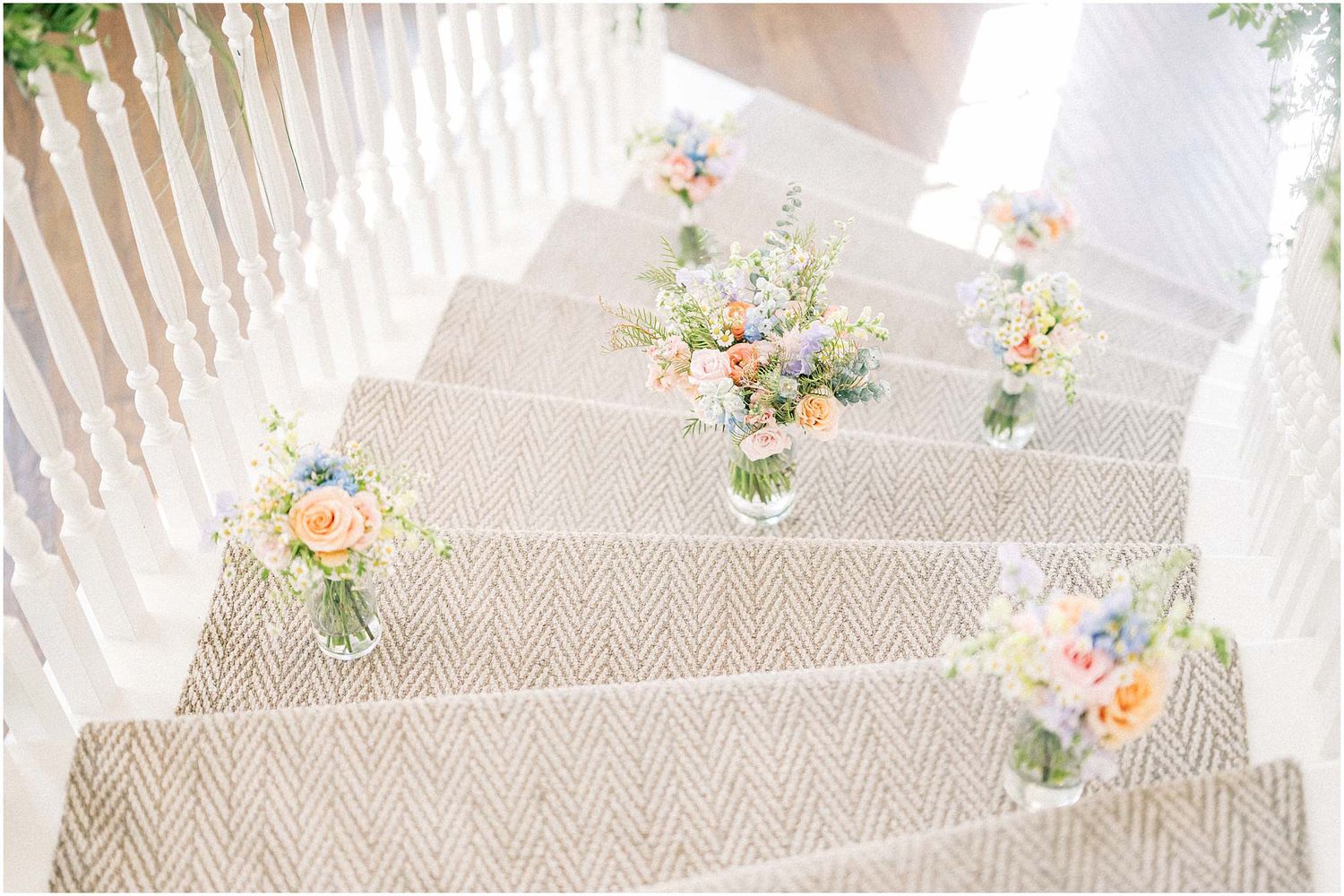 Carpeted staircase decorated with small floral arrangements along the steps.