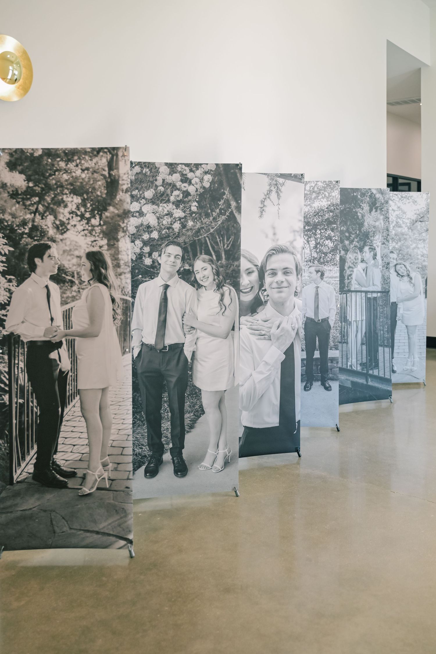 Black and white large format engagement photo banners displayed in a row at a wedding venue.