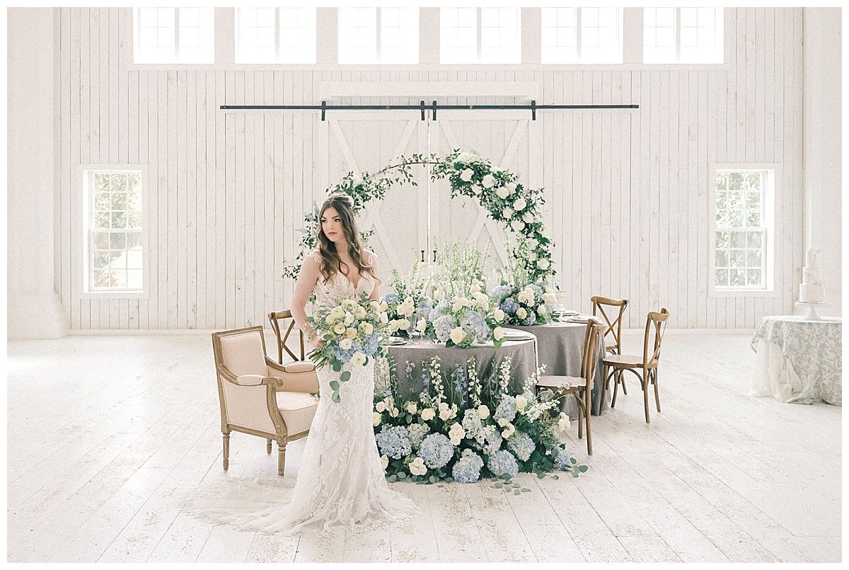 White modern wedding venue interior with light wood chairs and soft natural lighting.
