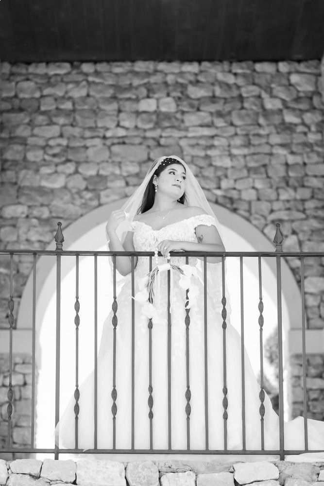 Black and white photos of a bride posing dramatically against stone architecture and metal railings.