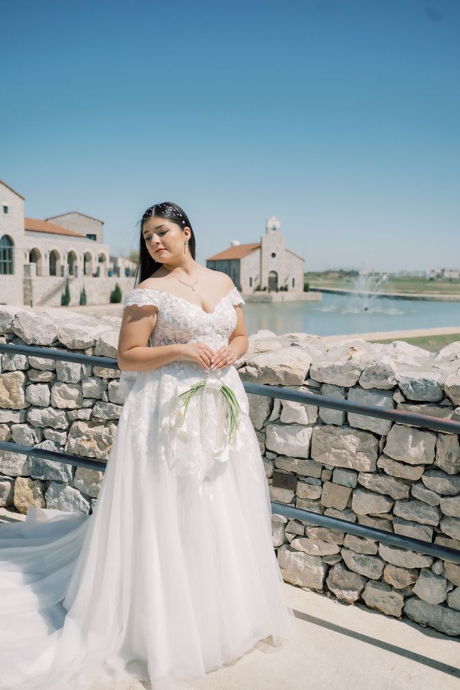 Coastal wedding photography featuring a white gown against stone walls and ocean views.