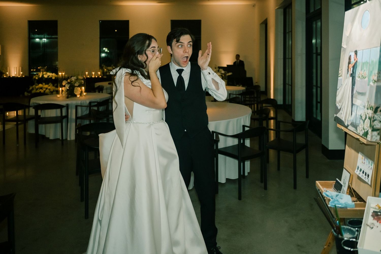 Bride and groom reacting with surprise and joy during wedding reception.