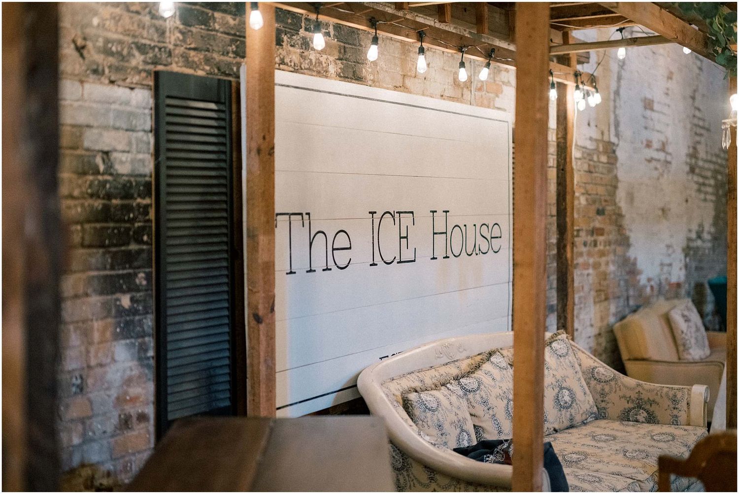 Rustic brick wall with 'The ICE House' text signage in an industrial-style venue.