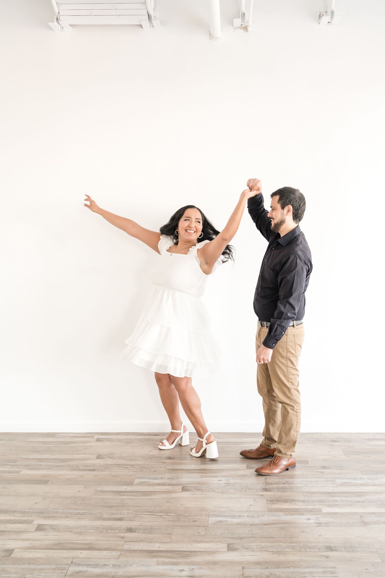 A joyful dance moment captured between a couple in contrasting outfits.