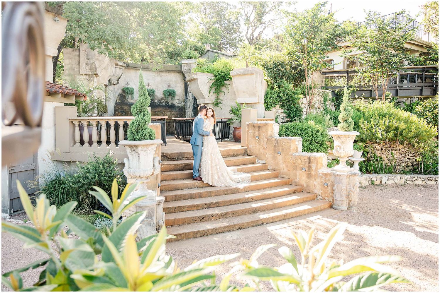 Stone steps and columns create an elegant outdoor garden setting with natural sunlight filtering through.