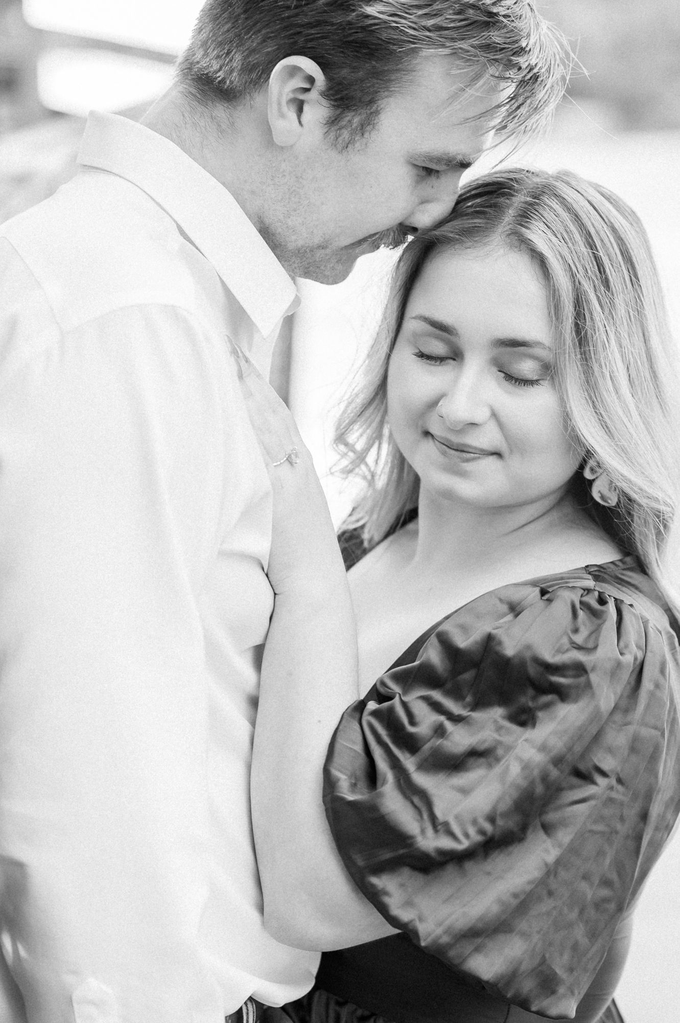 An intimate black and white portrait of a couple sharing a romantic moment during their engagement session.