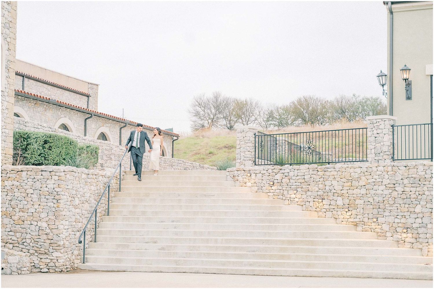 Stone archways and staircases create an elegant architectural backdrop at an outdoor venue.