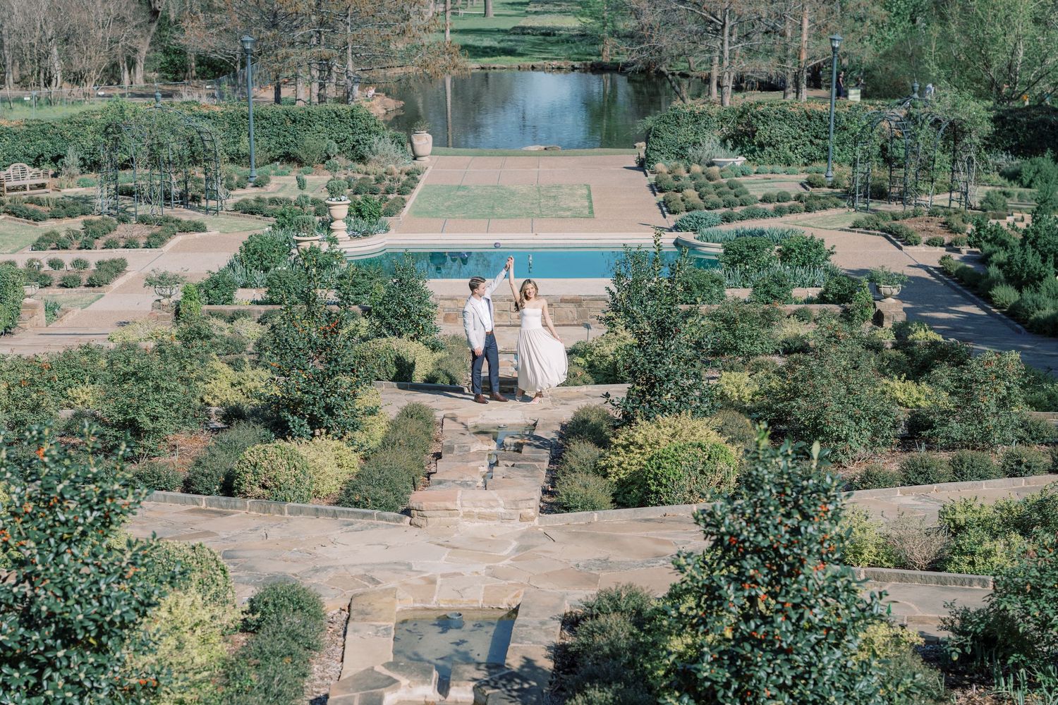A scenic garden pathway features stone steps winding through lush greenery and landscaped terraces.