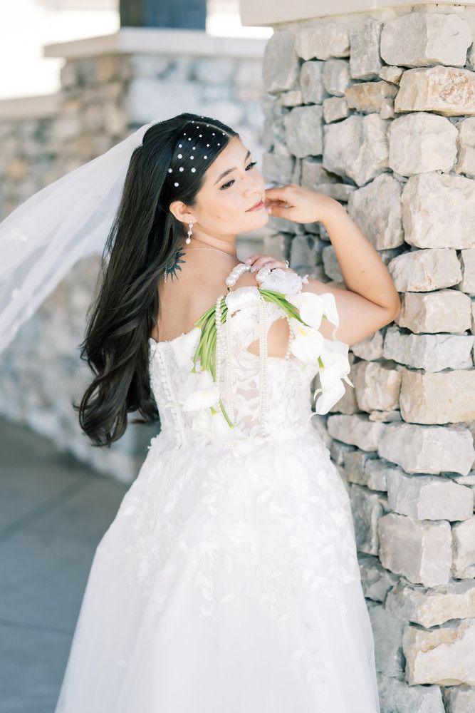 Romantic bridal portraits against stone architecture featuring a flowing white dress.