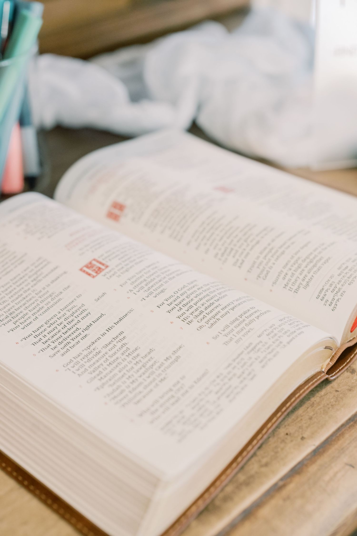 Open Bible with highlighted passages resting on wooden surface at wedding preparation area.