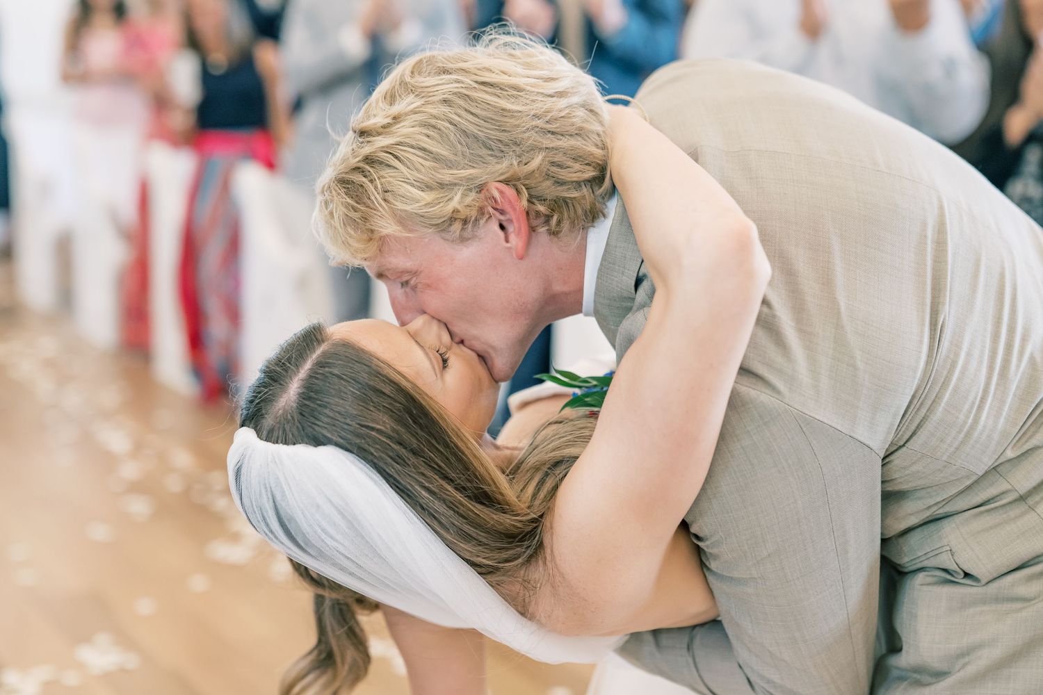 Newlyweds sharing romantic first kiss dip on the wedding dance floor.