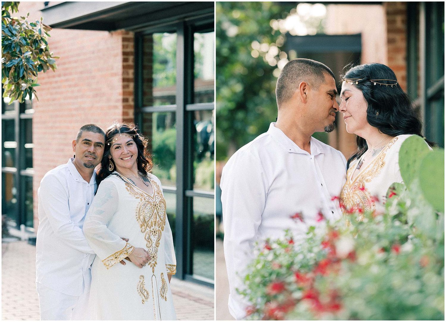A couple shares intimate moments near blooming flowers and brick buildings.