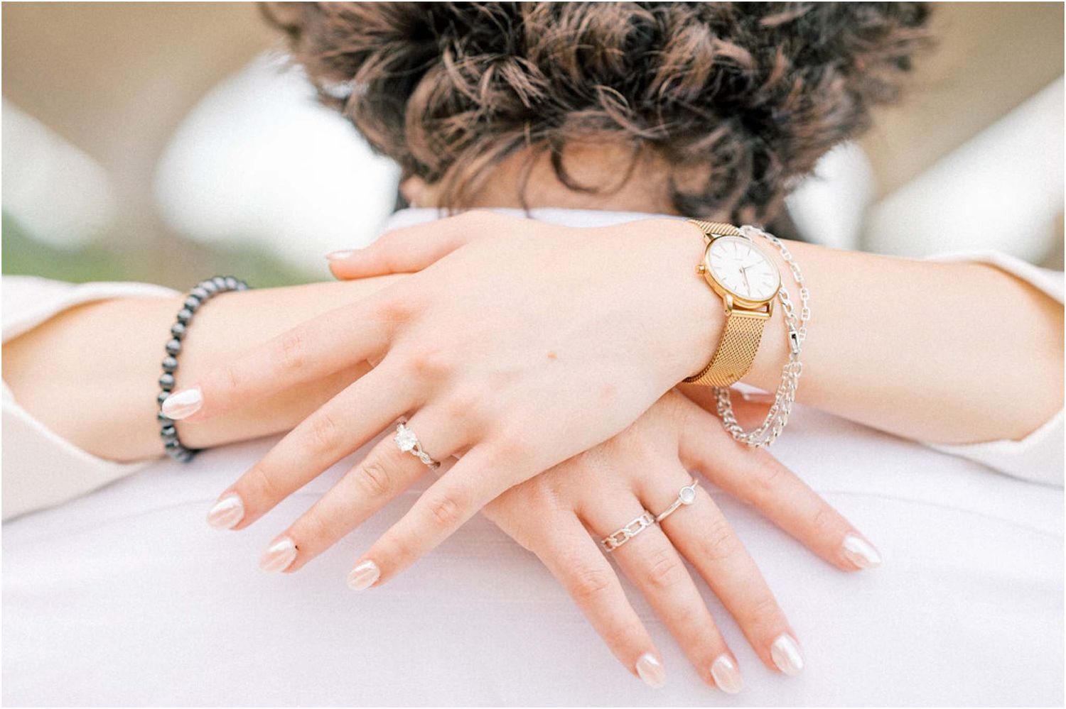 Close-up shots of hands displaying engagement rings on white background.