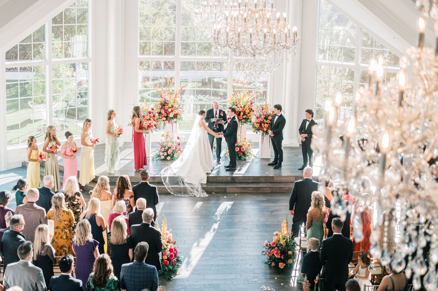 Luxurious wedding reception hall with crystal chandeliers and large windows.