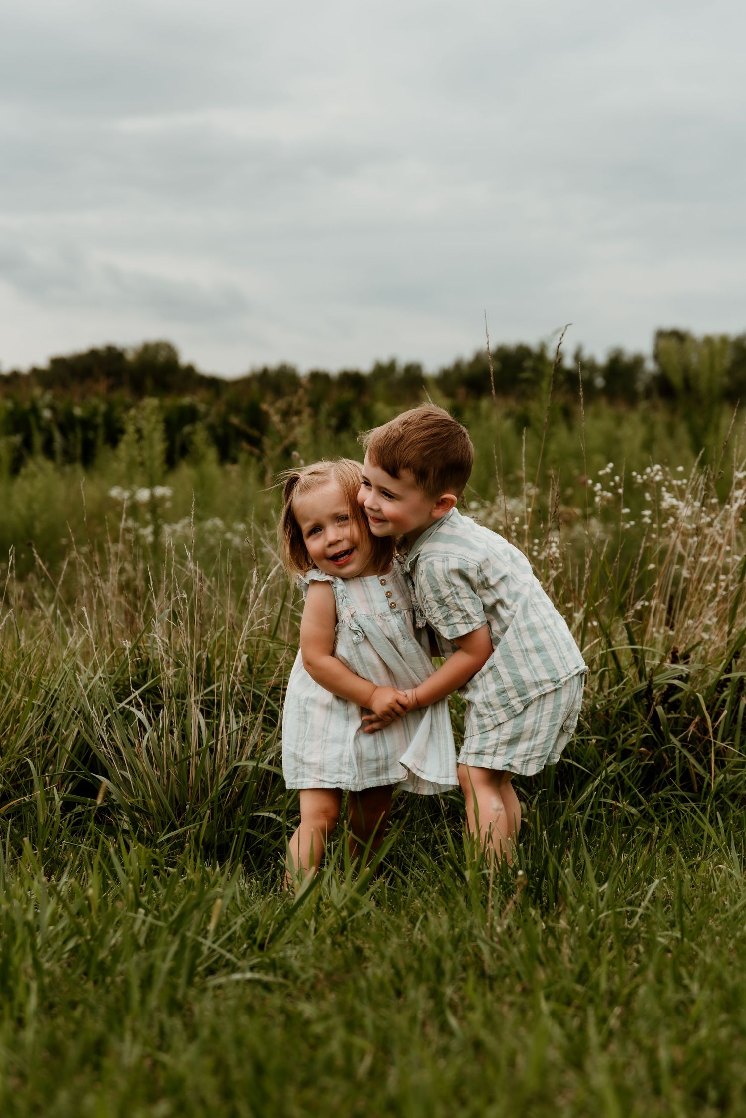 Siblings in a grassy field in Twelve Mile, Indiana