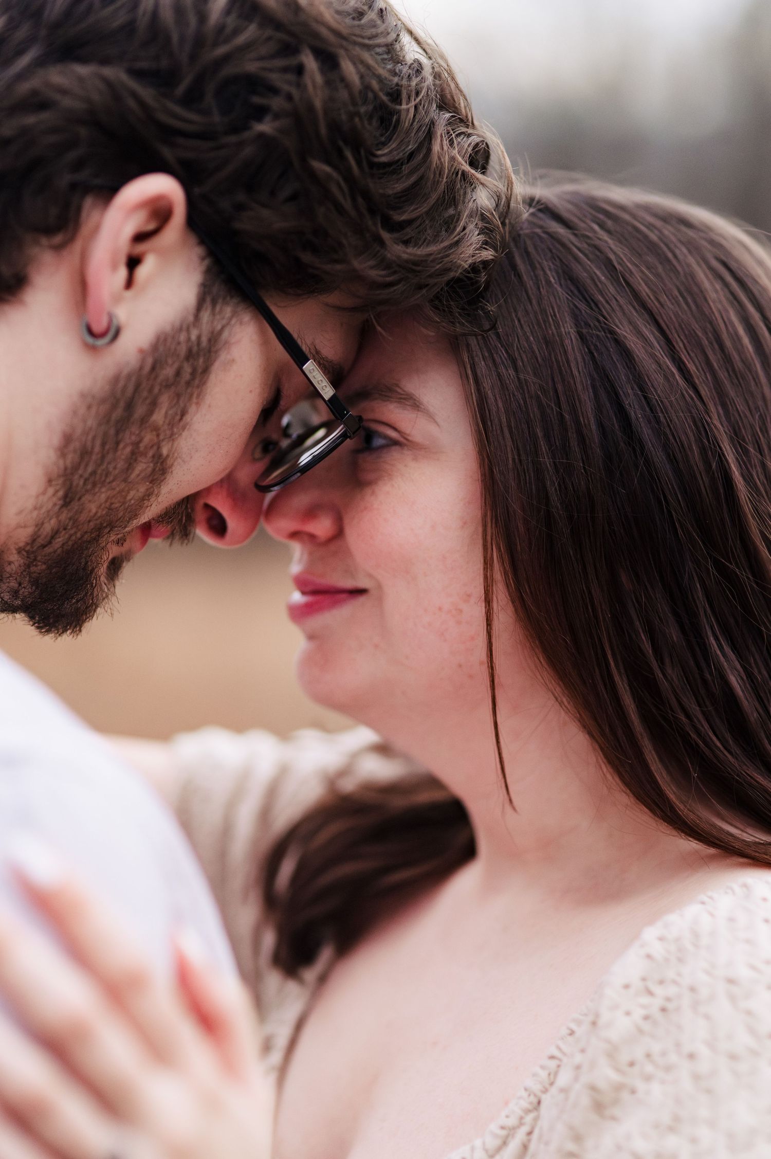 Close-up romantic moments captured between a couple in soft natural lighting.
