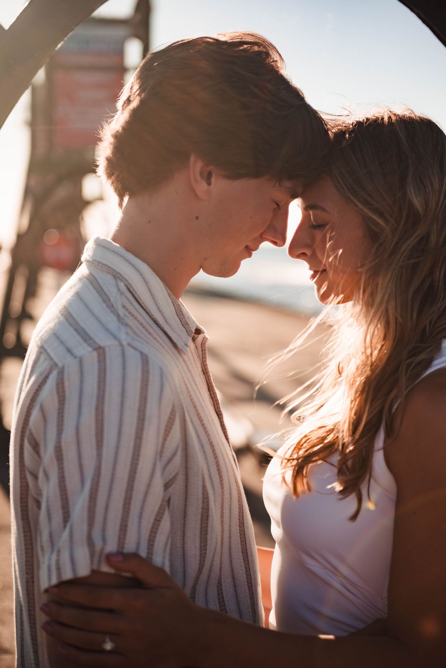 Intimate sunset moment captured between couple with golden light streaming through.
