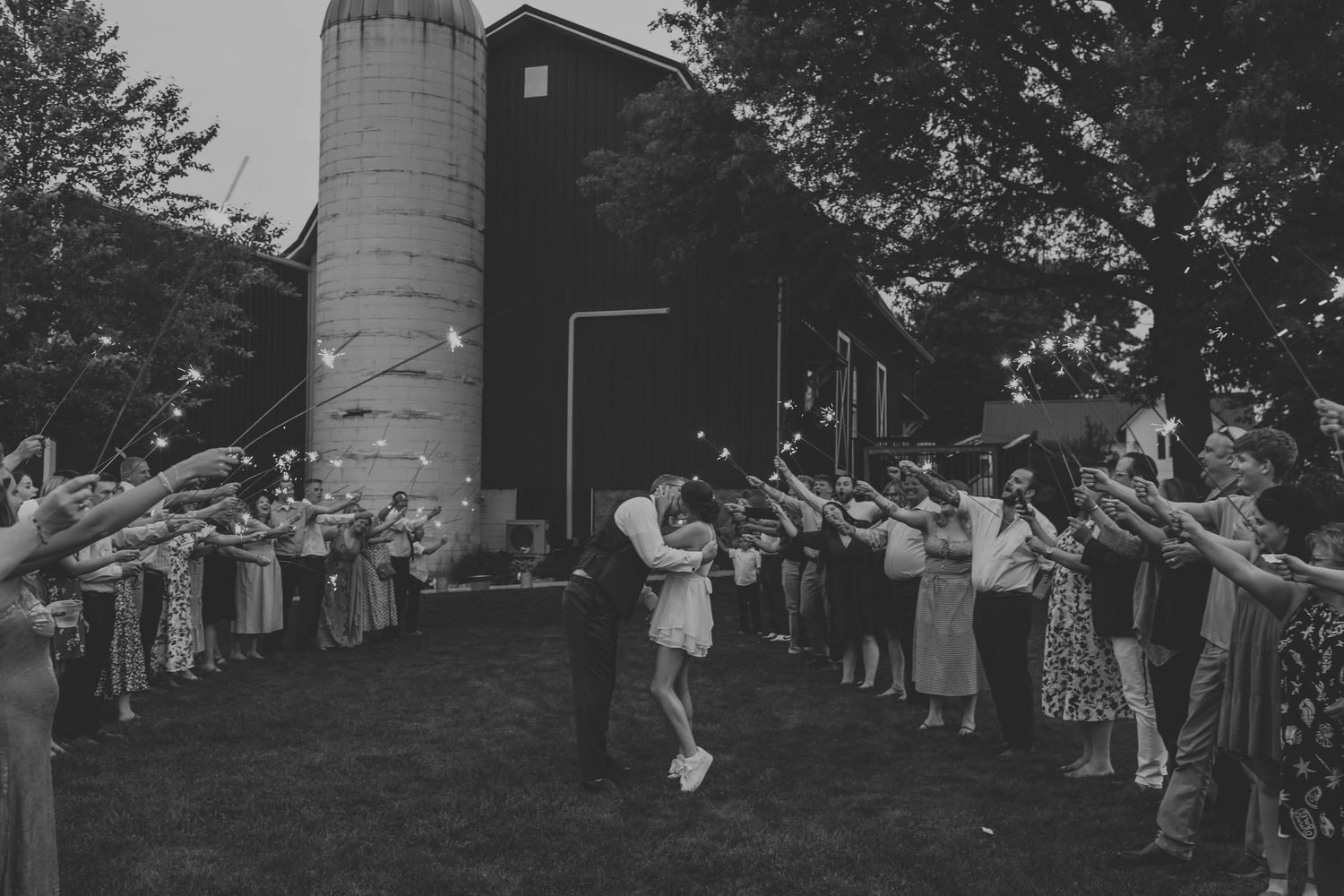 Black and white wedding party photo sequence with silo and barn backdrop.