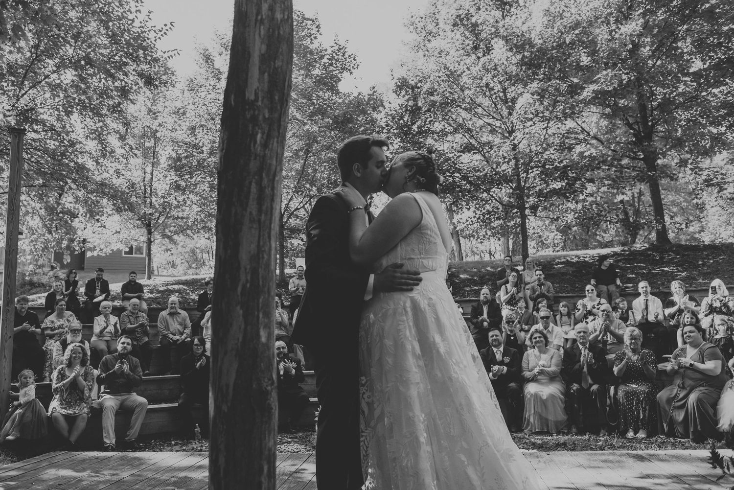 Black and white photograph of a wedding ceremony with guests seated outdoors.