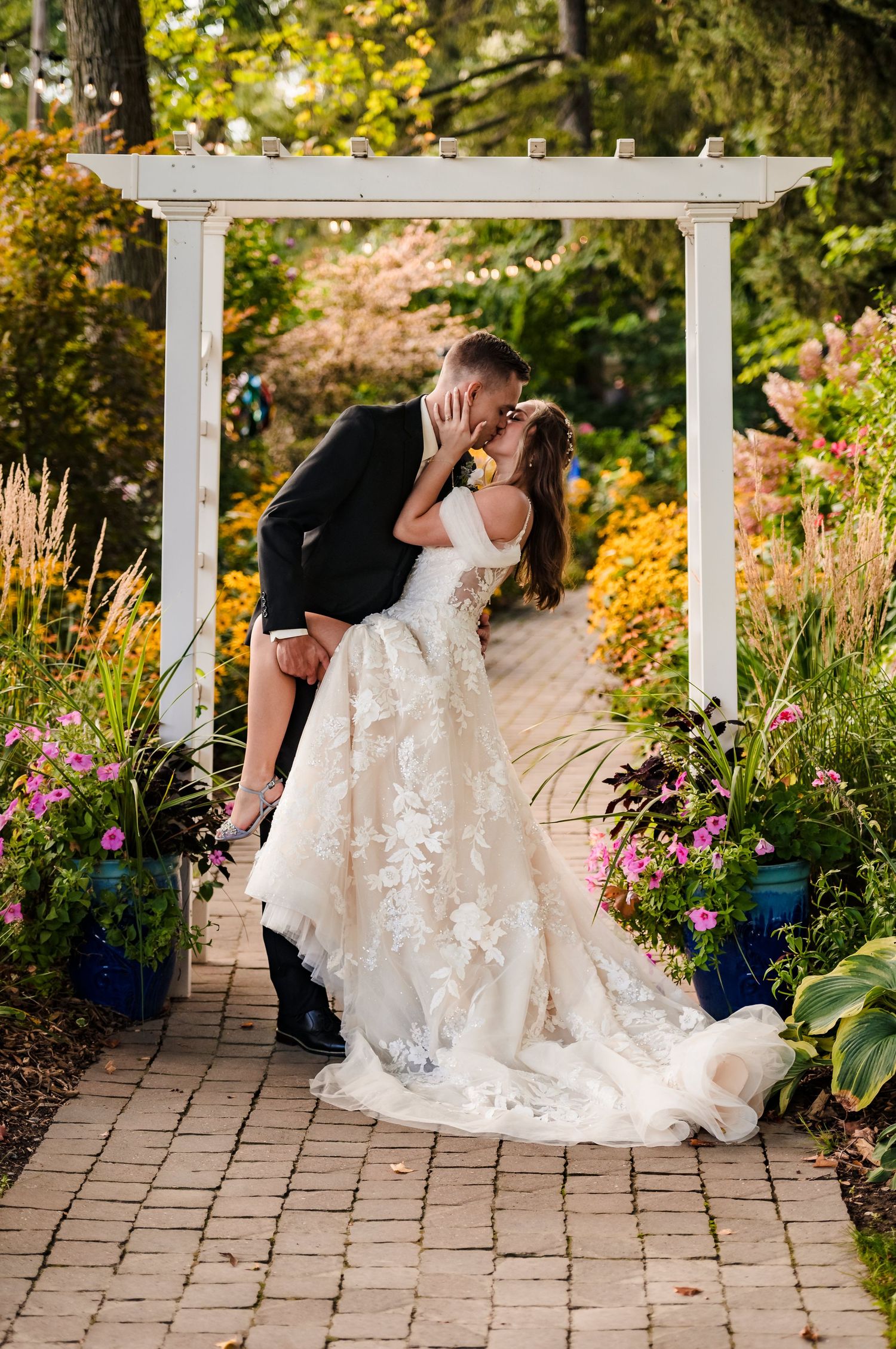 White pergola garden path with flowing wedding dress details.