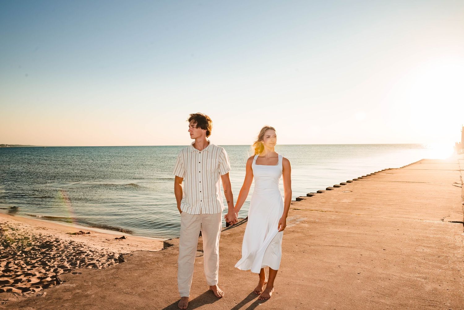 Romantic beach photoshoot at sunset with warm golden light and ocean views.