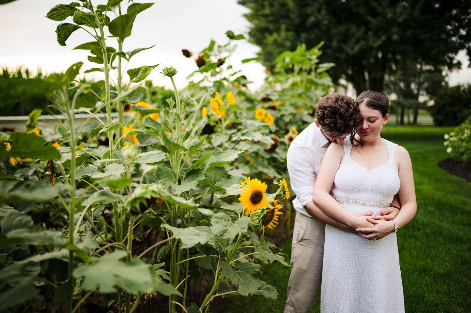 Garden wedding photos with sunflowers and greenery creating natural backdrop.