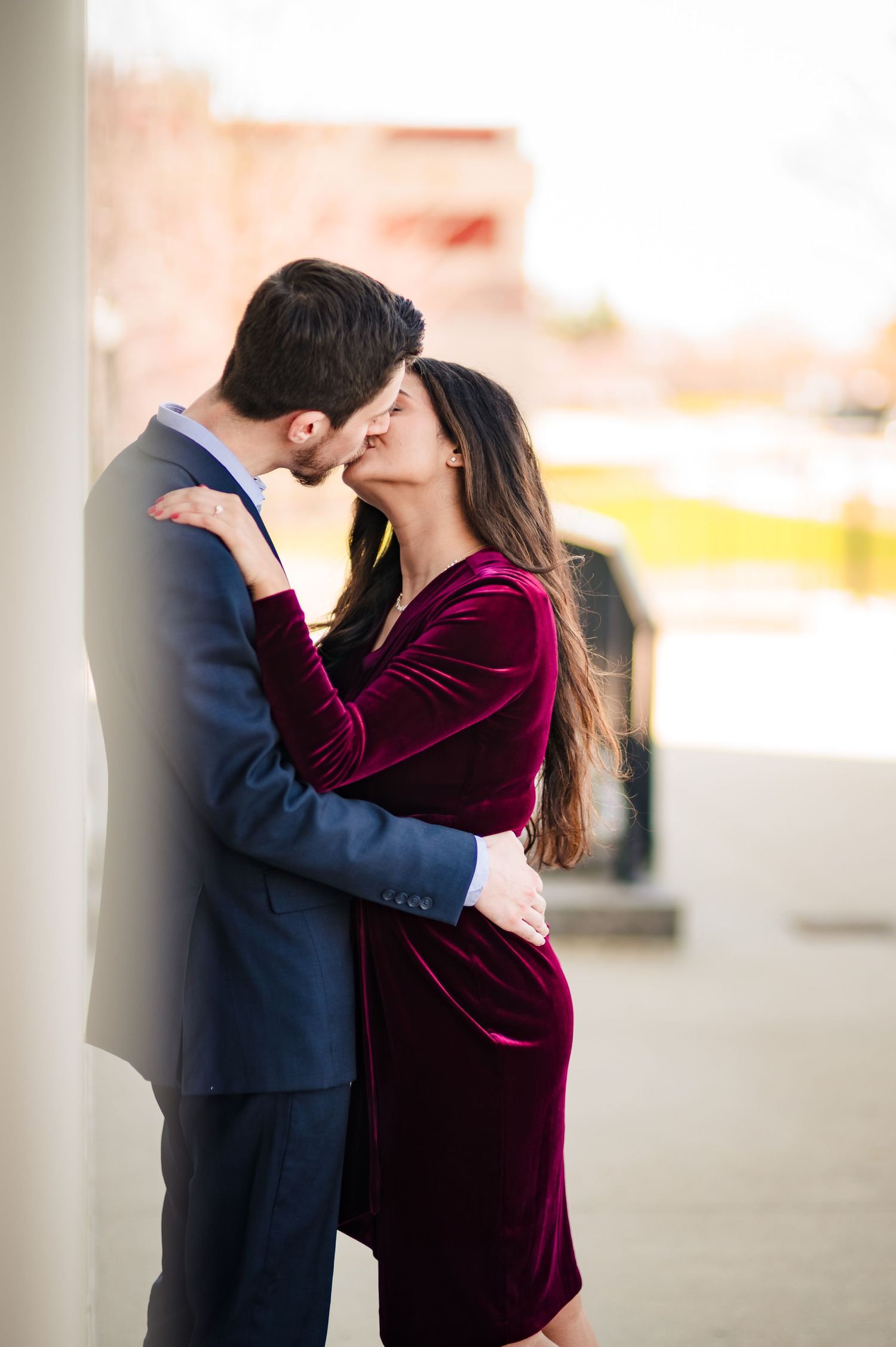 Intimate moment captured in a parking structure with warm lighting and burgundy velvet details.
