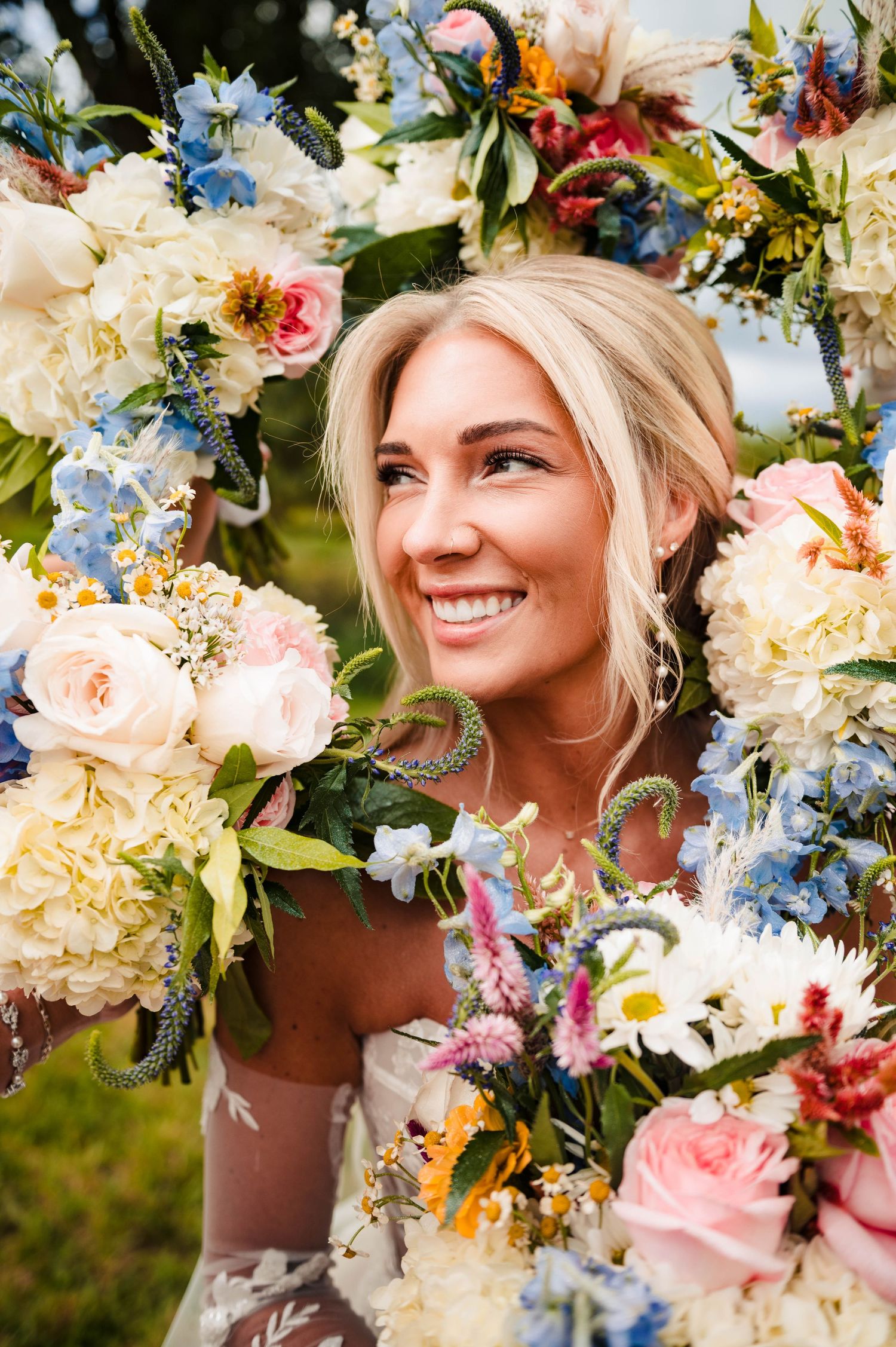 Colorful floral arrangement frames a wedding portrait with blue and pink blooms.