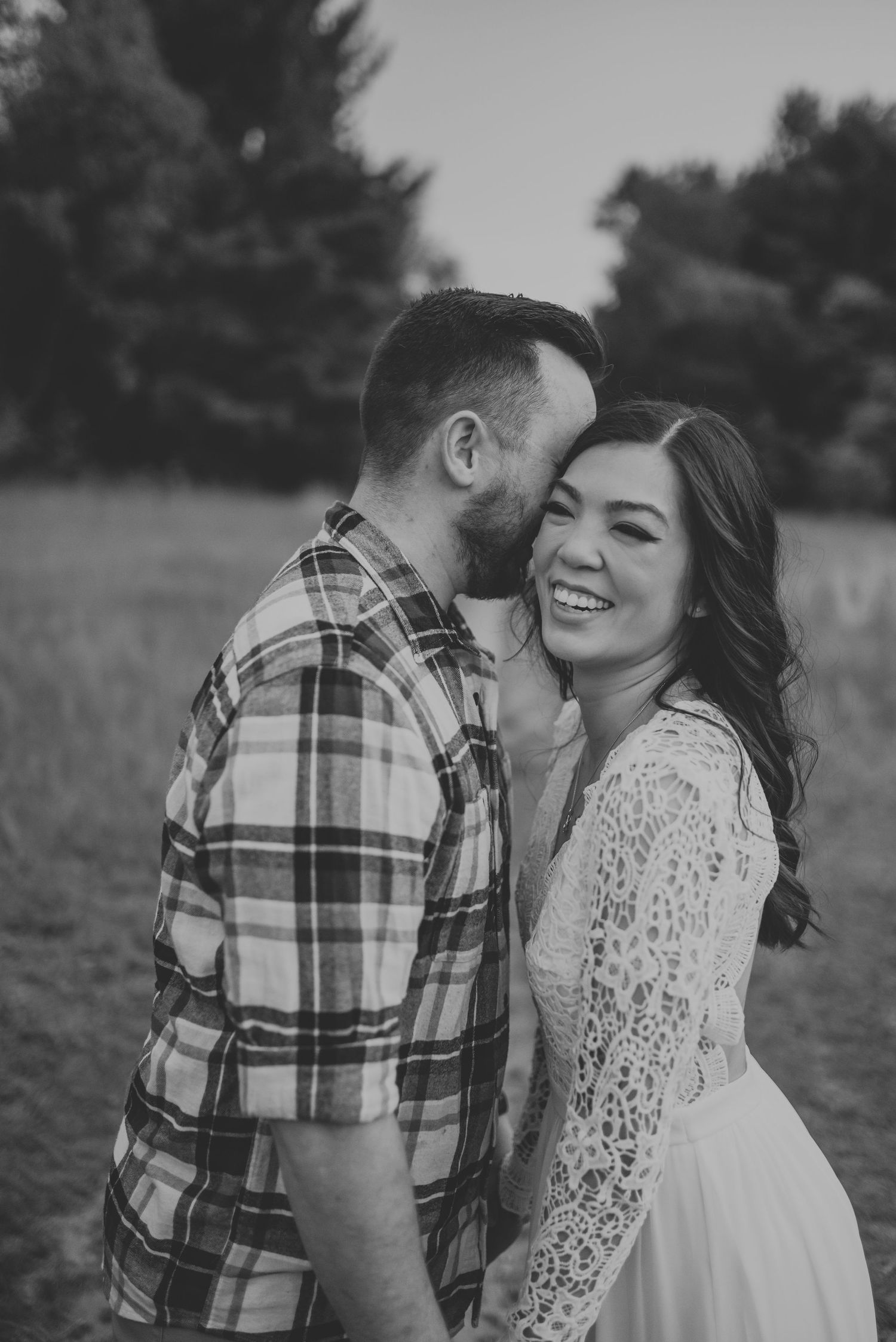 Couple in casual attire sharing playful moment in outdoor setting.