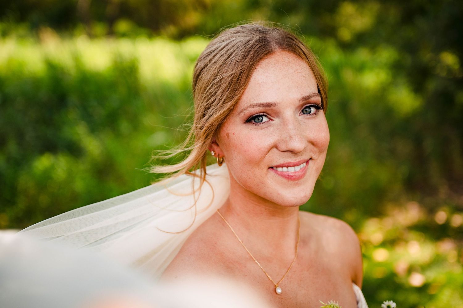 Outdoor bridal portraits with natural sunlit background and soft bokeh effect.
