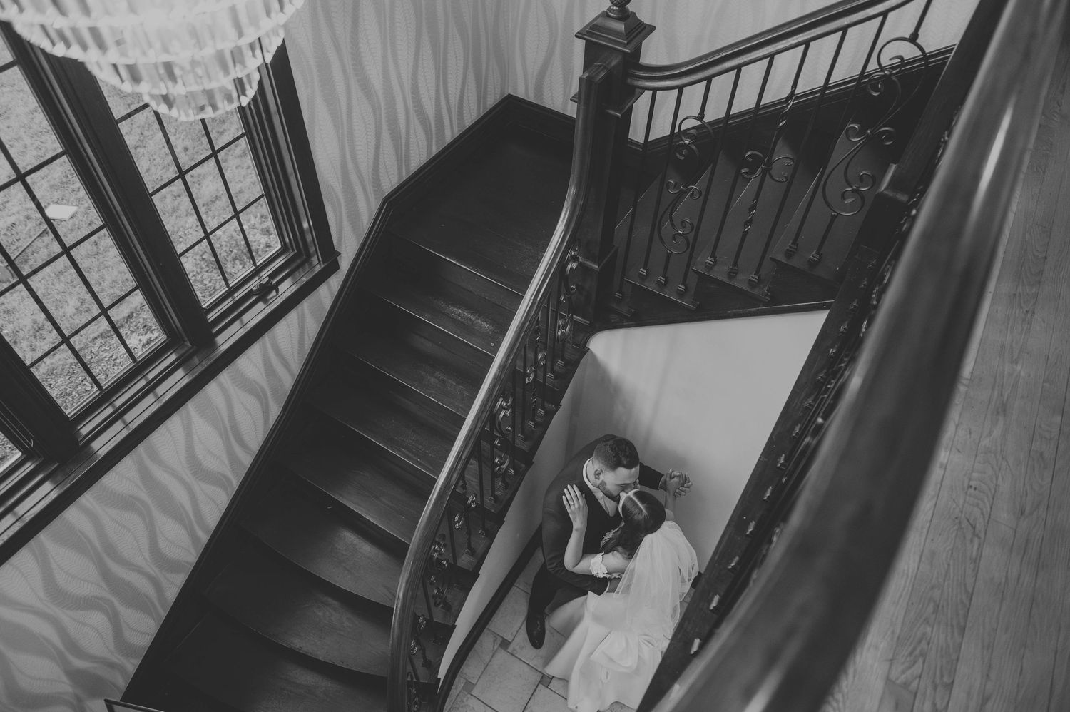 Elegant black and white staircase photos with dramatic chandelier lighting and shadows.