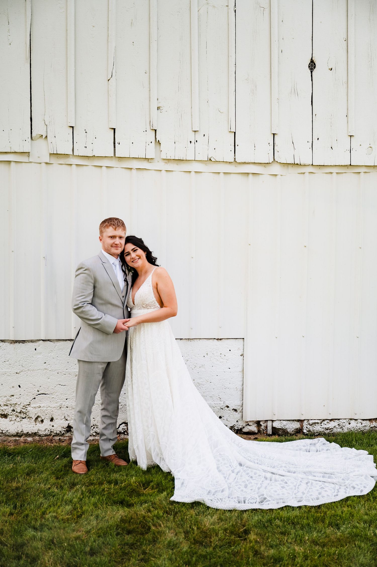 Classic wedding portraits against rustic white barn backdrop.