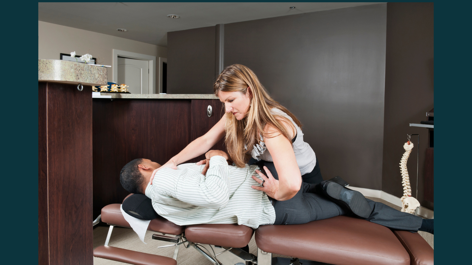 A chiropractor performing manual spinal mobilisation on a patient to treat hypomobility & disc pathologies at a professional clinic