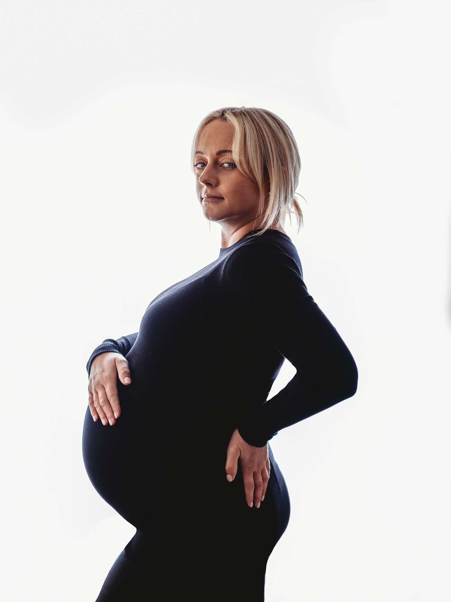 Silhouette of pregnant woman in black against white background showing progression of poses.