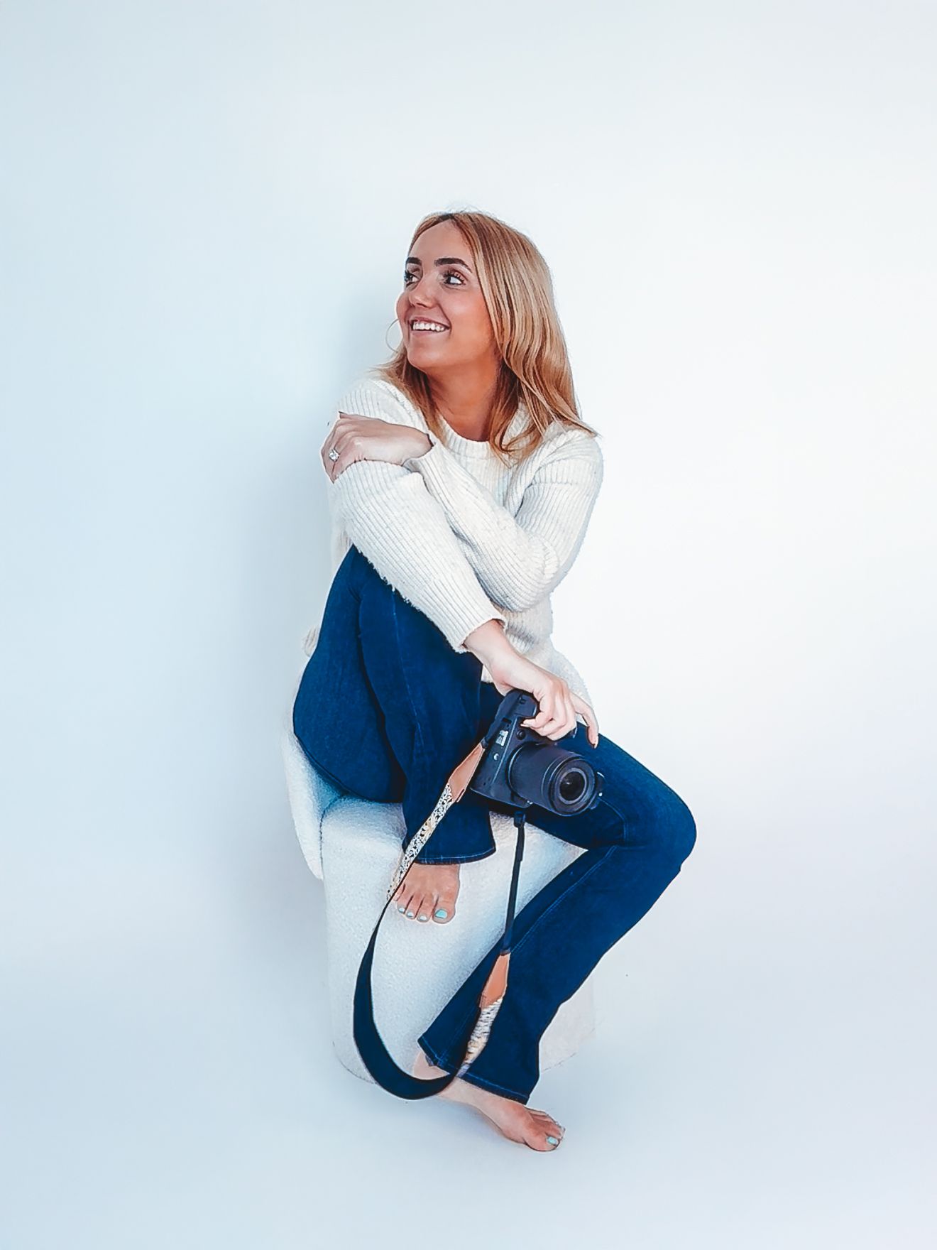 Person wearing white sweater and blue jeans poses in four different crouching positions against white background.