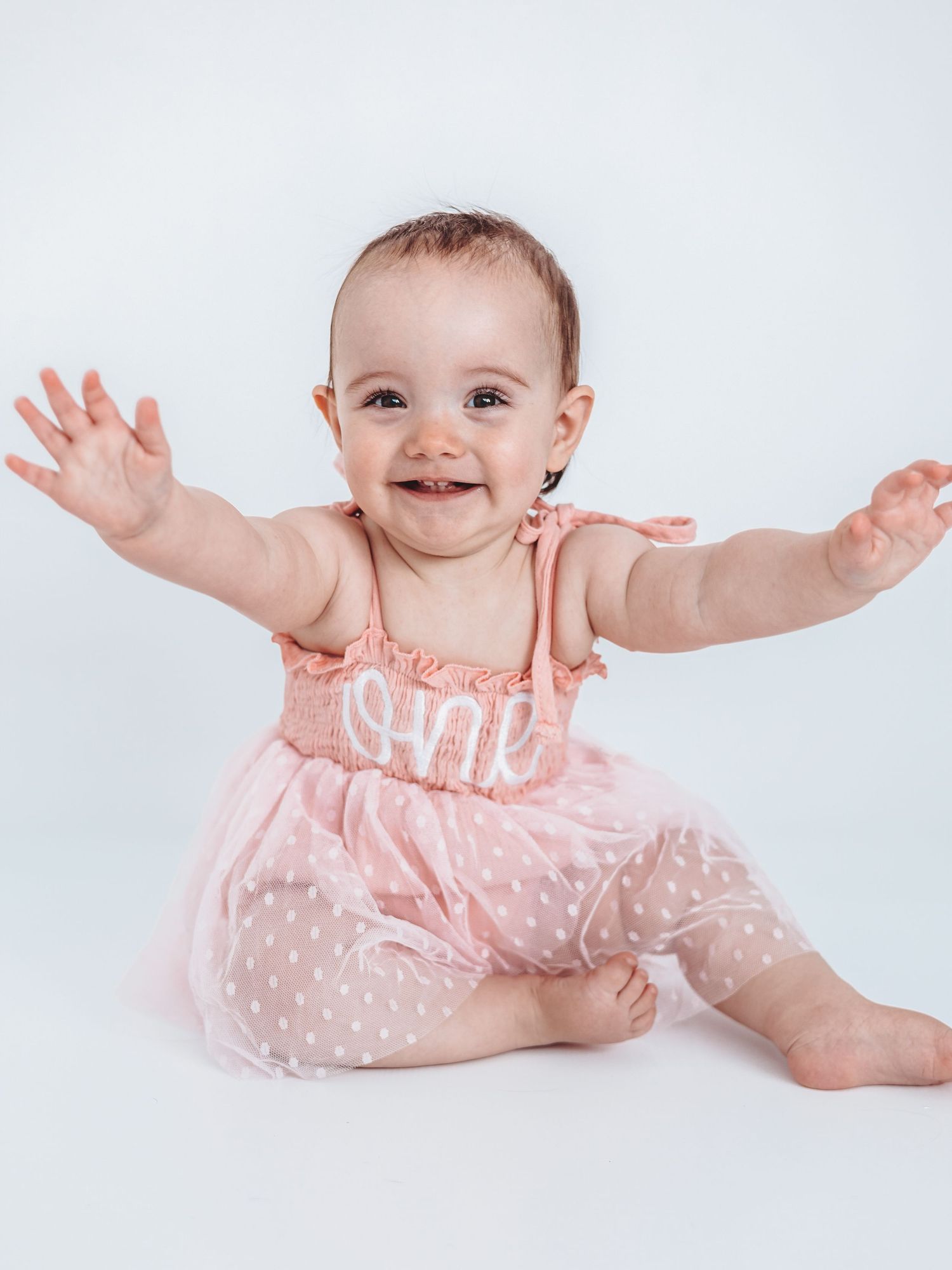 A smiling baby girl in a pink \