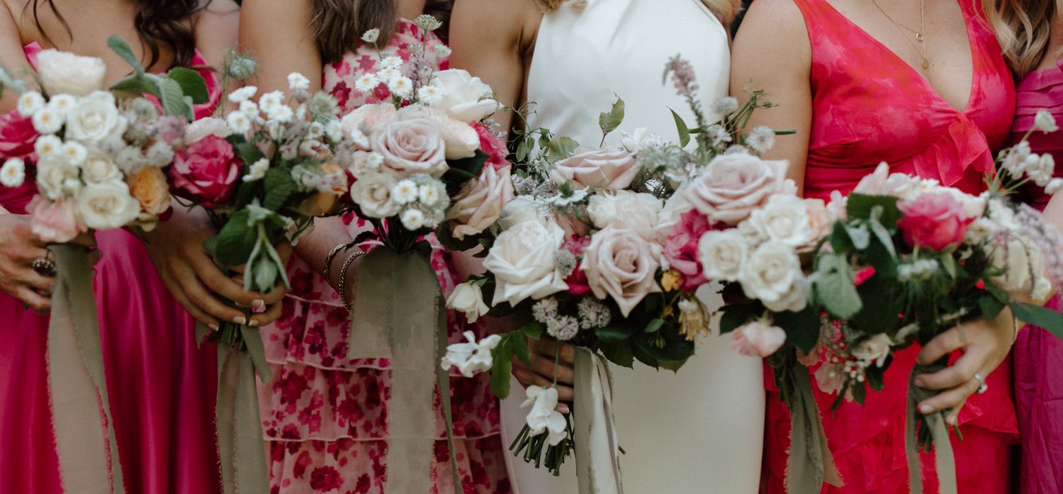 Close-up of pink and white wedding bouquets with roses and mixed flowers.