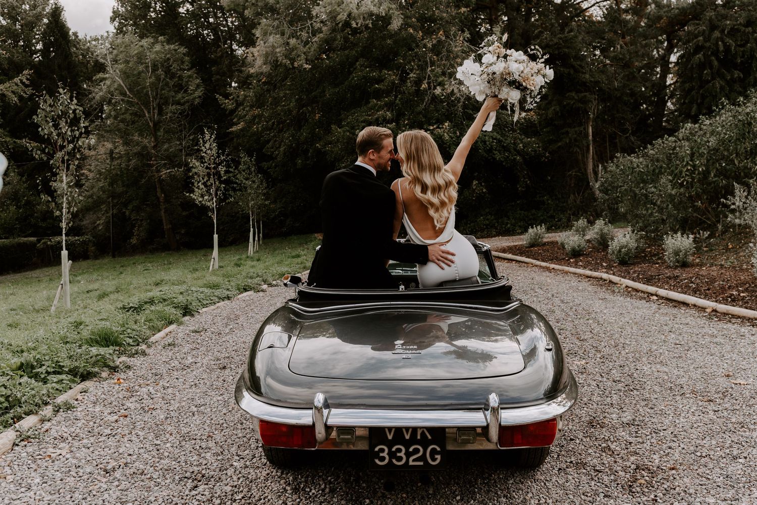Vintage car with elegant couple in a natural outdoor setting for couple portraits.